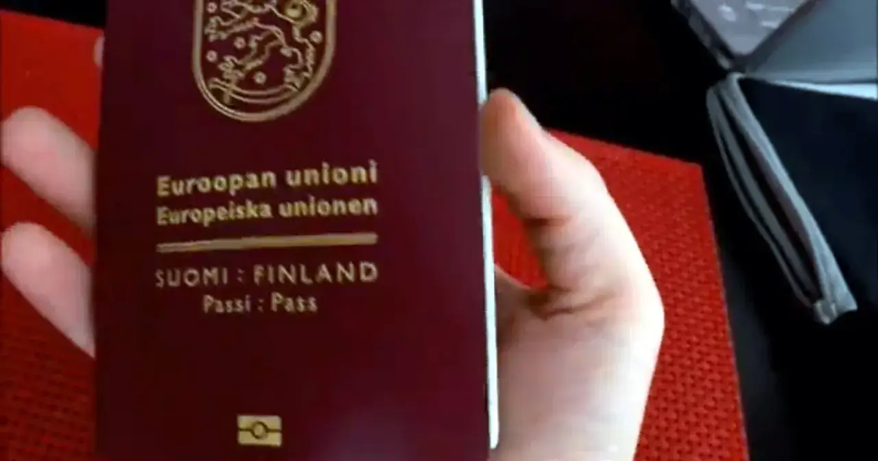 Dłoń trzyma paszport Finlandii. Czy do Finlandii potrzebny jest paszport? Tak, jeśli nie jesteś obywatelem UE.