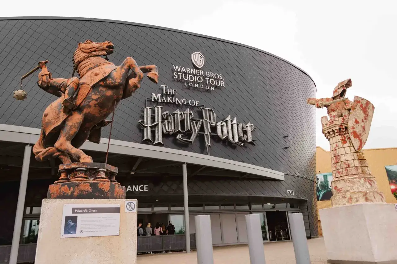 Przed wejściem do muzeum Harry'ego Pottera stoją figury szachowe z filmu, rycerz na koniu i wieża.