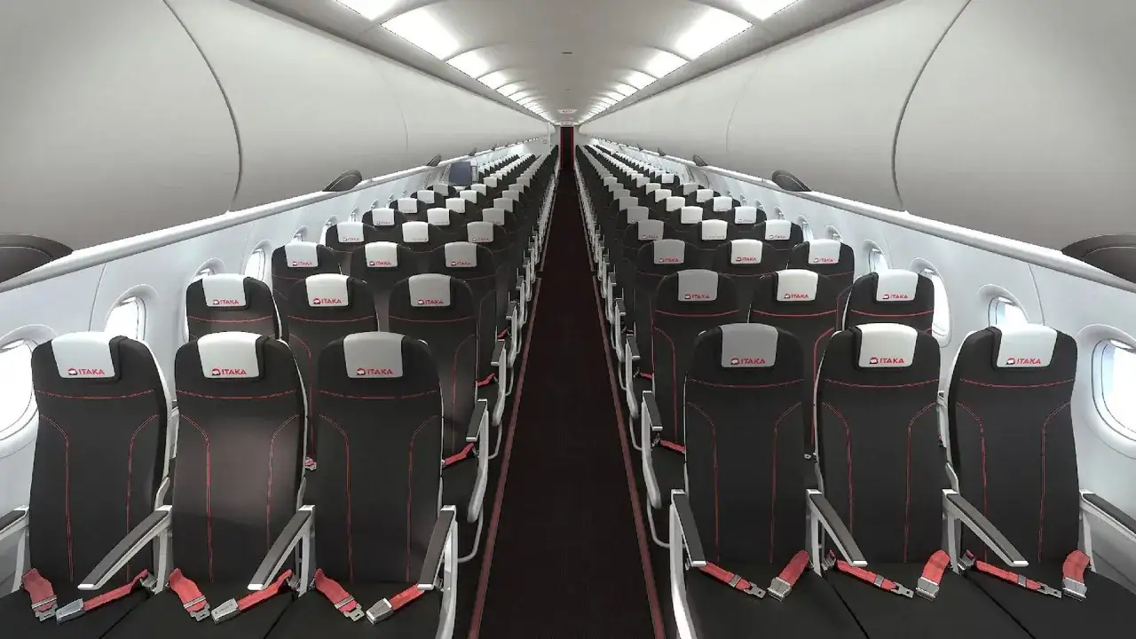 Wnętrze samolotu linii lotniczych Electra Airways z rzędami czarnych foteli z czerwonymi przeszyciami i logo 