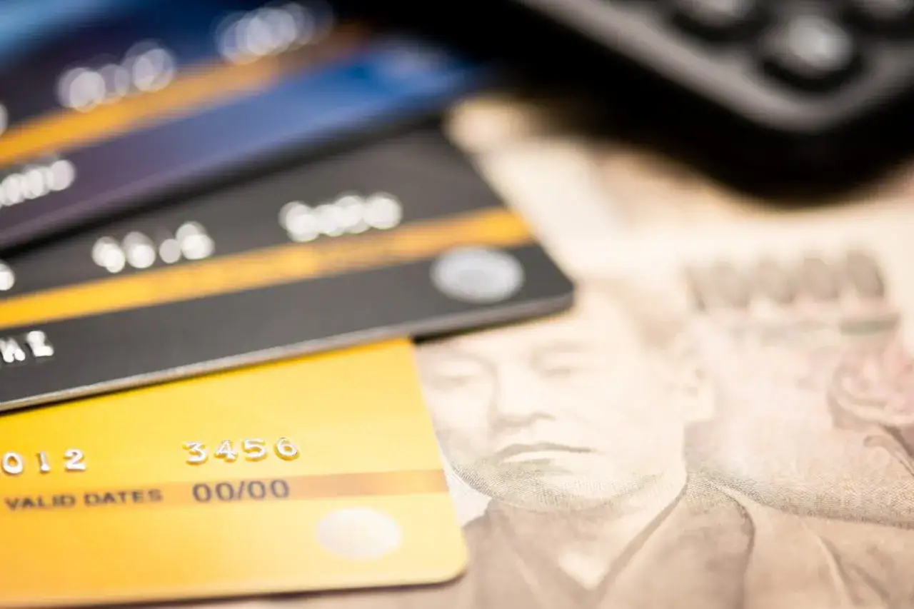 Zbliżenie na karty płatnicze leżące na banknocie 10000 jenów. Nowoczesne płatności i tradycyjna japonia waluta.