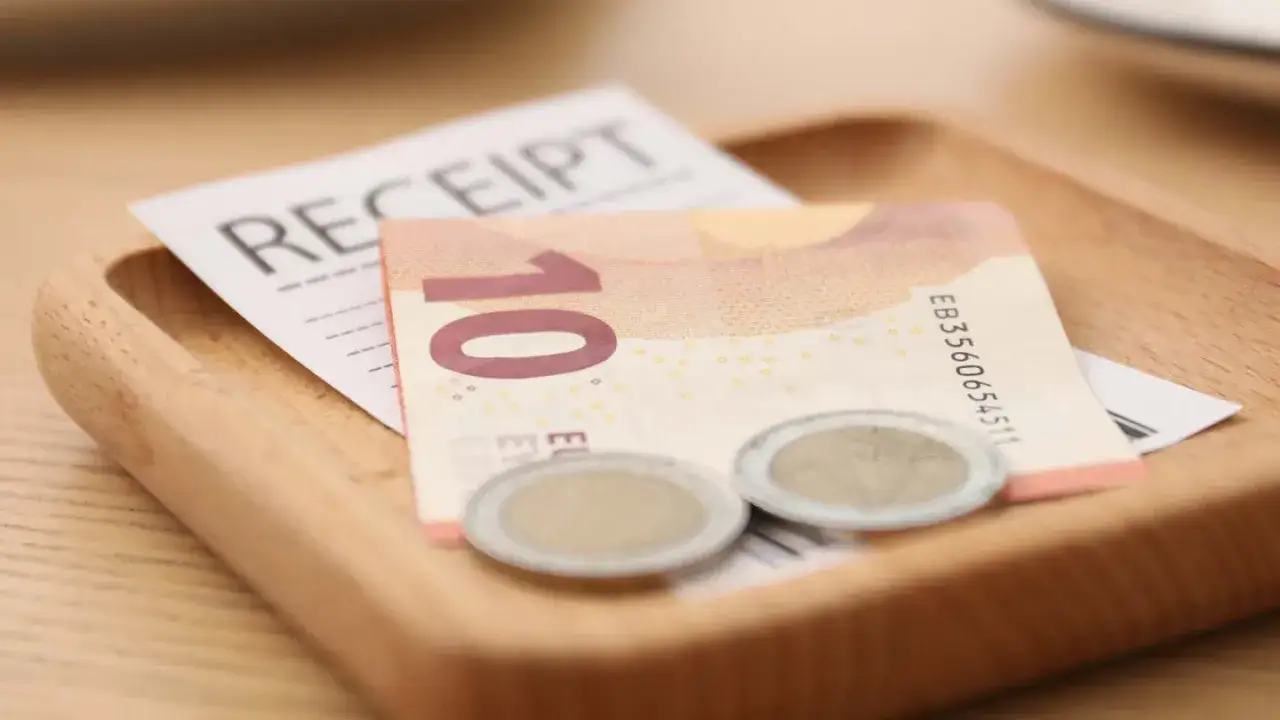 Dziesięcioeuro banknot i monety na rachunku w drewnianej miseczce. To waluta w Austrii, gotowa do zapłaty.