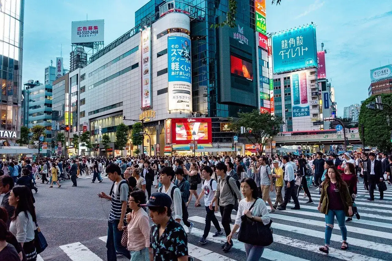 Tłum ludzi na ruchliwym skrzyżowaniu w Tokio. Zastanawiasz się, ile kosztuje wycieczka do Japonii?