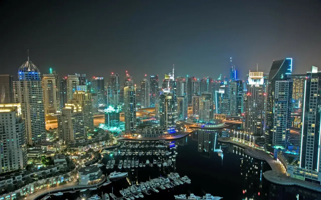 Nocny widok na Dubaj z drapaczami chmur i mariną pełną jachtów. Czy w Dubaju jest bezpiecznie? Tak, to nowoczesne i bezpieczne miasto.