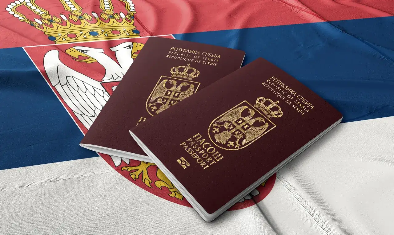 Dwa paszporty Republiki Serbii leżą na fladze Serbii. Czy do Serbii potrzebny jest paszport? Tak, do podróży do Serbii potrzebny jest paszport.