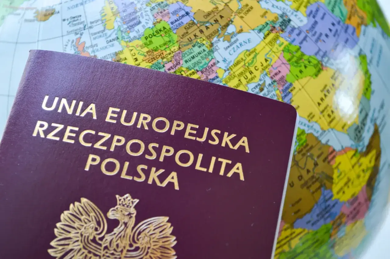 Polski paszport na tle globusa. Zastanawiasz się, ile kosztuje paszport, by wyruszyć w podróż?